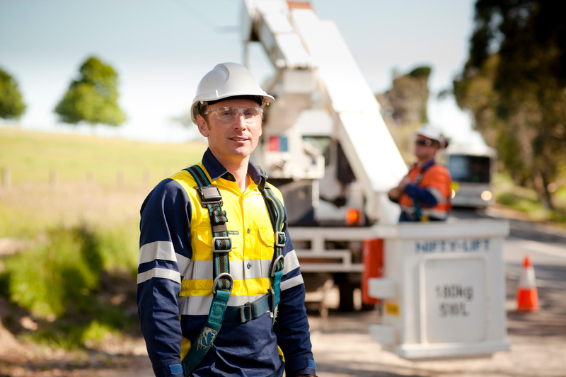 A man in high-vis standing outside near heavy machinery