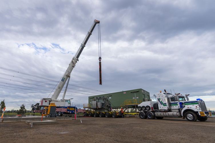 A truck and crane moving electricity infrastructure