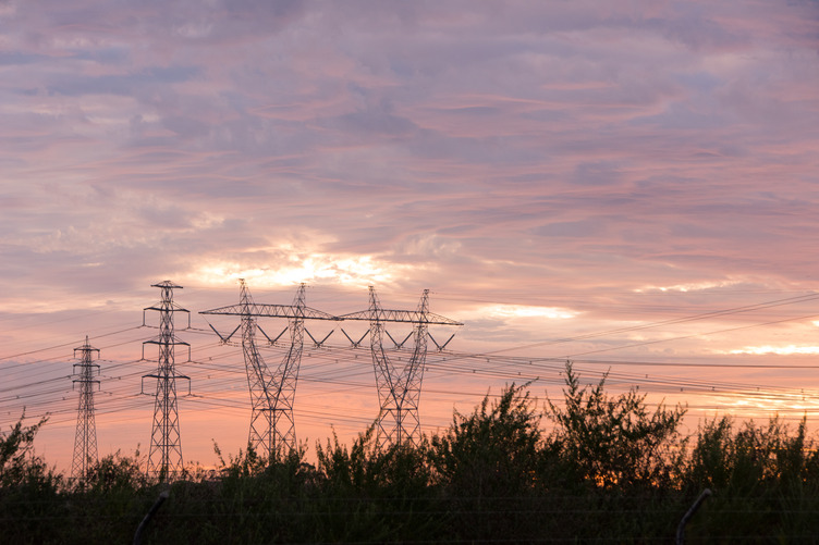 Four transmission towers at dusk