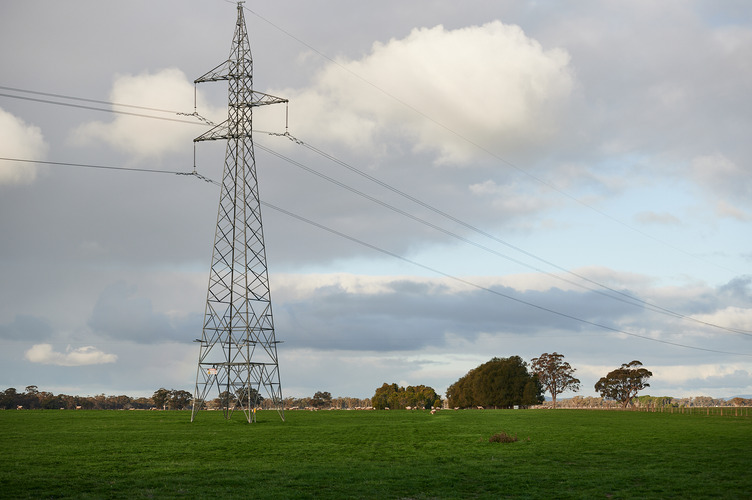 A transmission tower in a grassy field