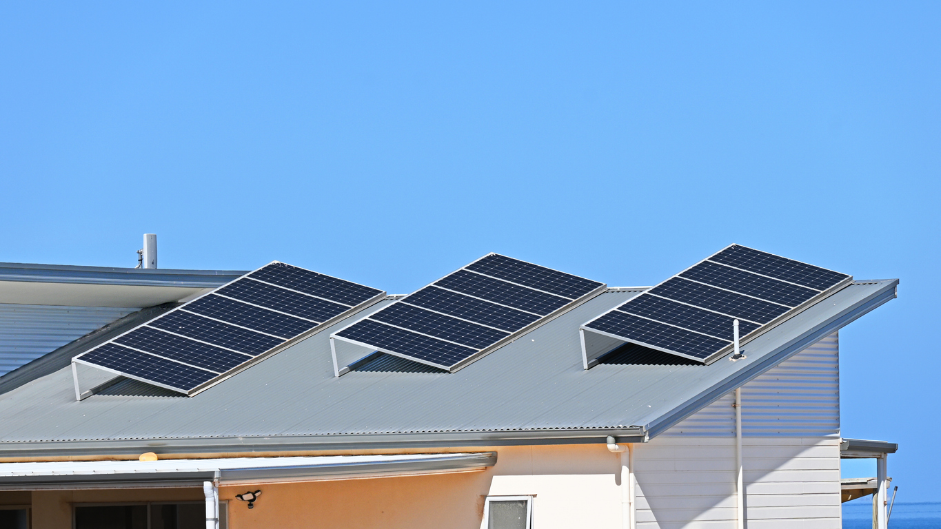 A row of three solar panels on a roof