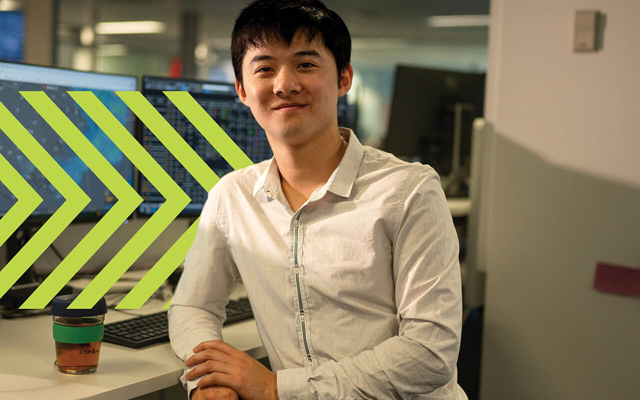 A man sitting at a desk smiling at the camera