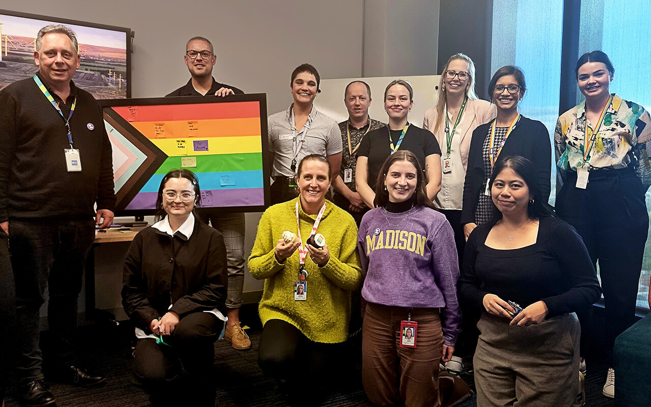 A group of people, one of them holding an LGBT flag