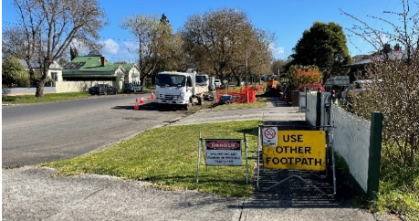A 'danger' and 'use other footpath' sign on a pavement
