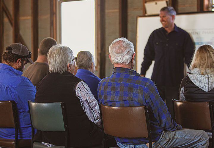 A man presenting to a seated group of people