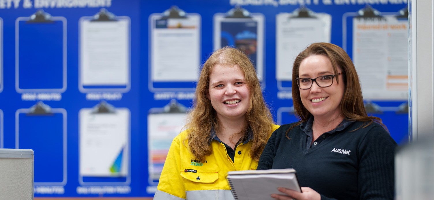 Two AusNet workers smiling in an office
