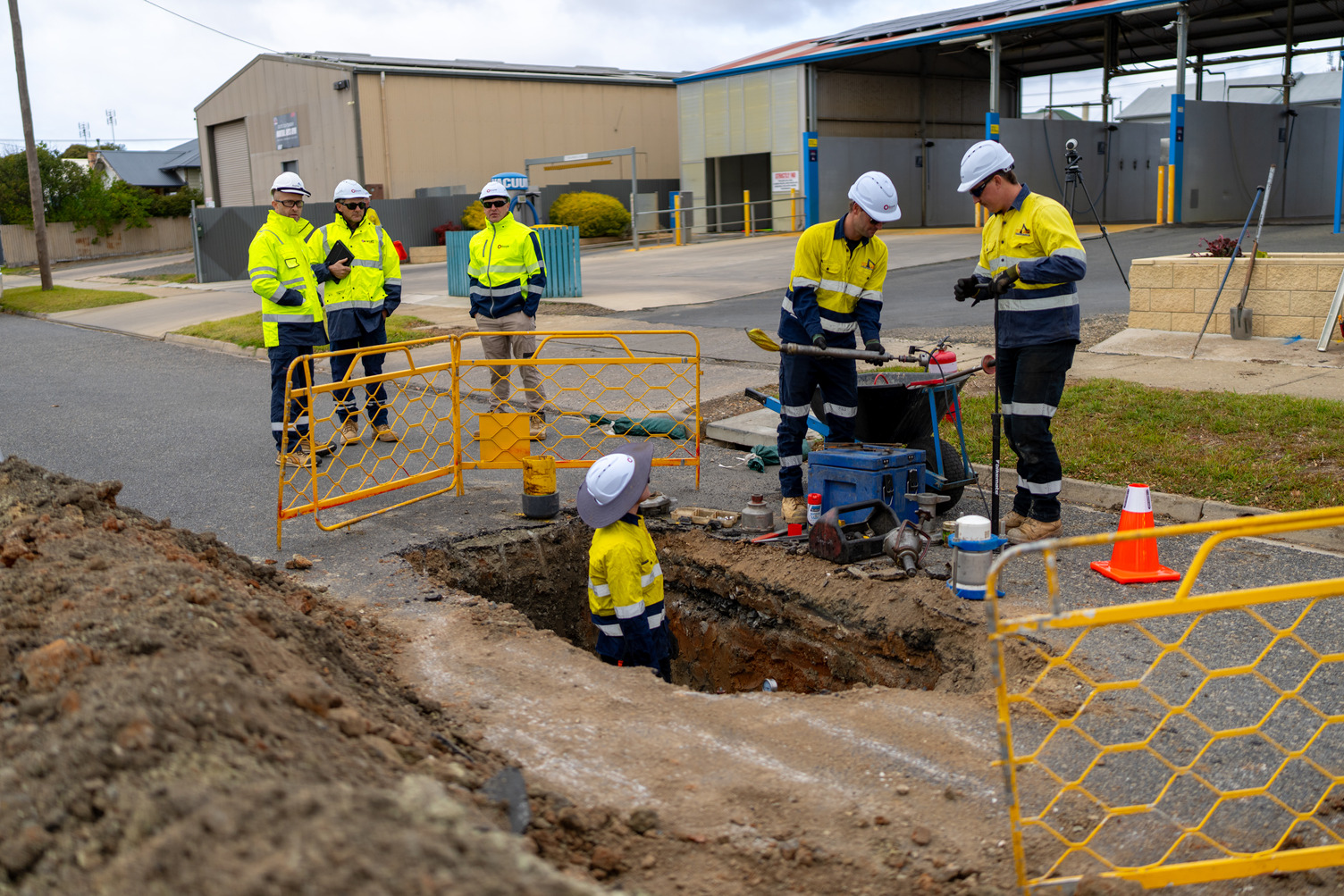 A large group of people outside working on a gas pipe