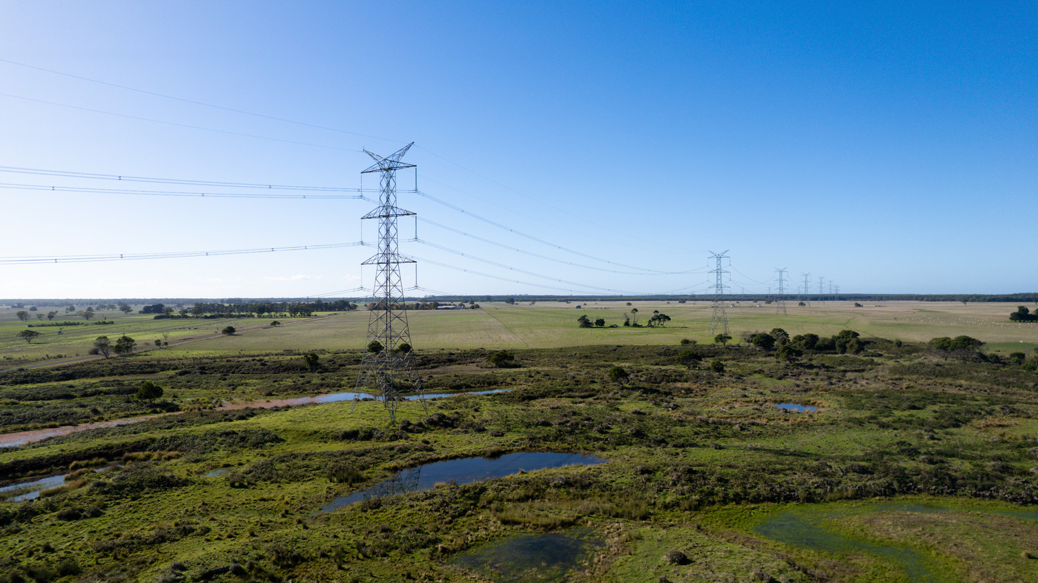 Transmission towers spanning across an open field