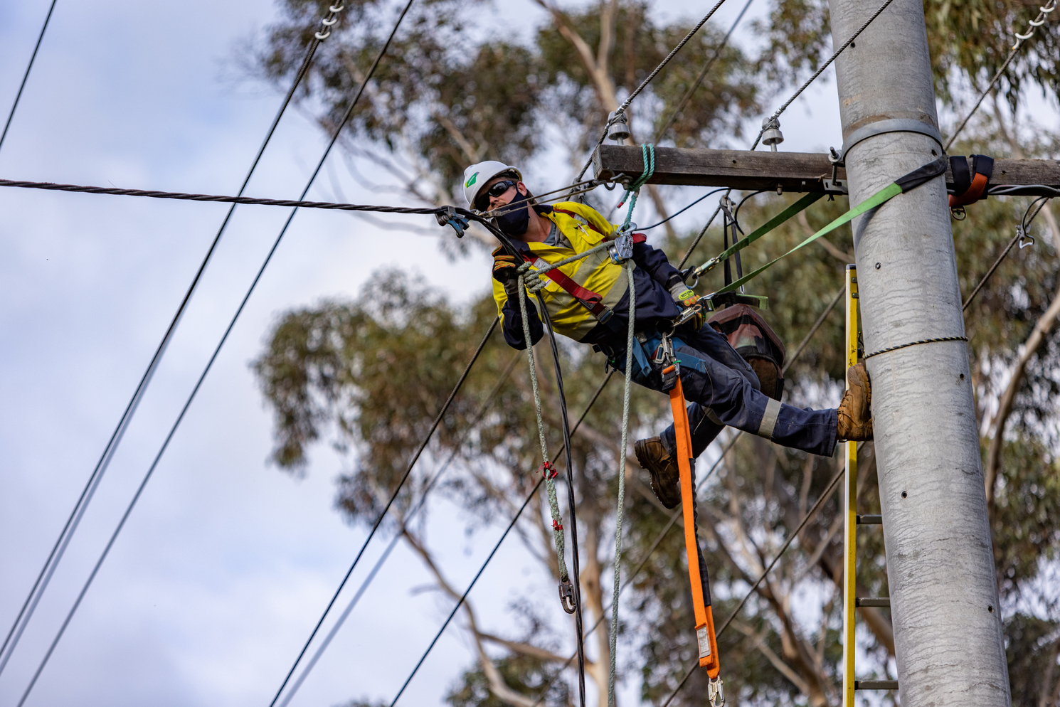 A man wearing high-vis working on a powerline