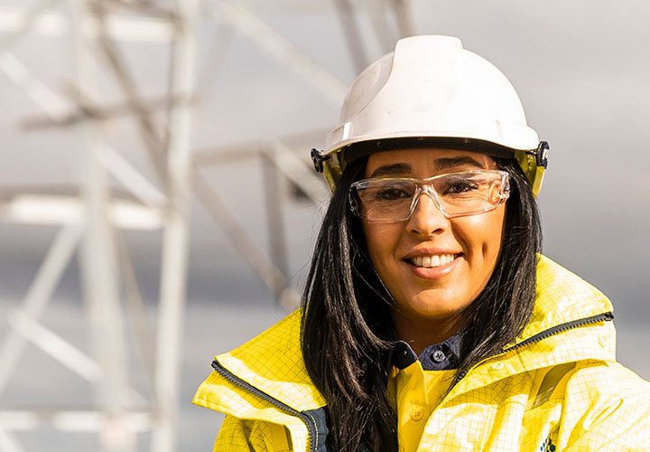 Woman in high vis standing in front of a power line