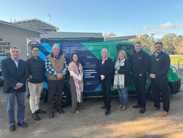 A group of people standing outside near a van