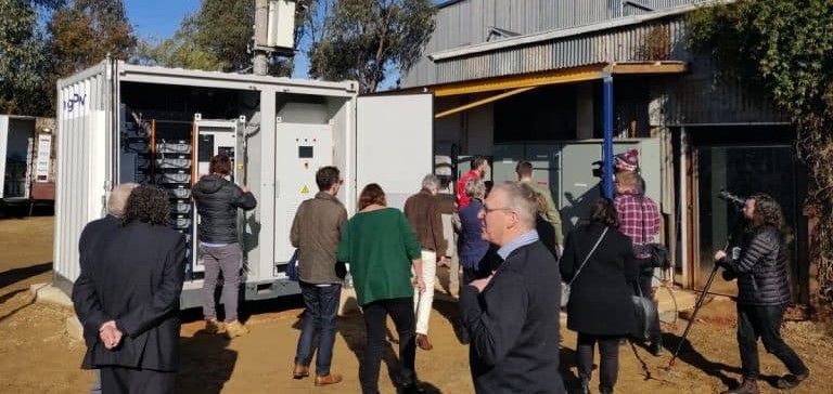 A group of people outside near a large battery