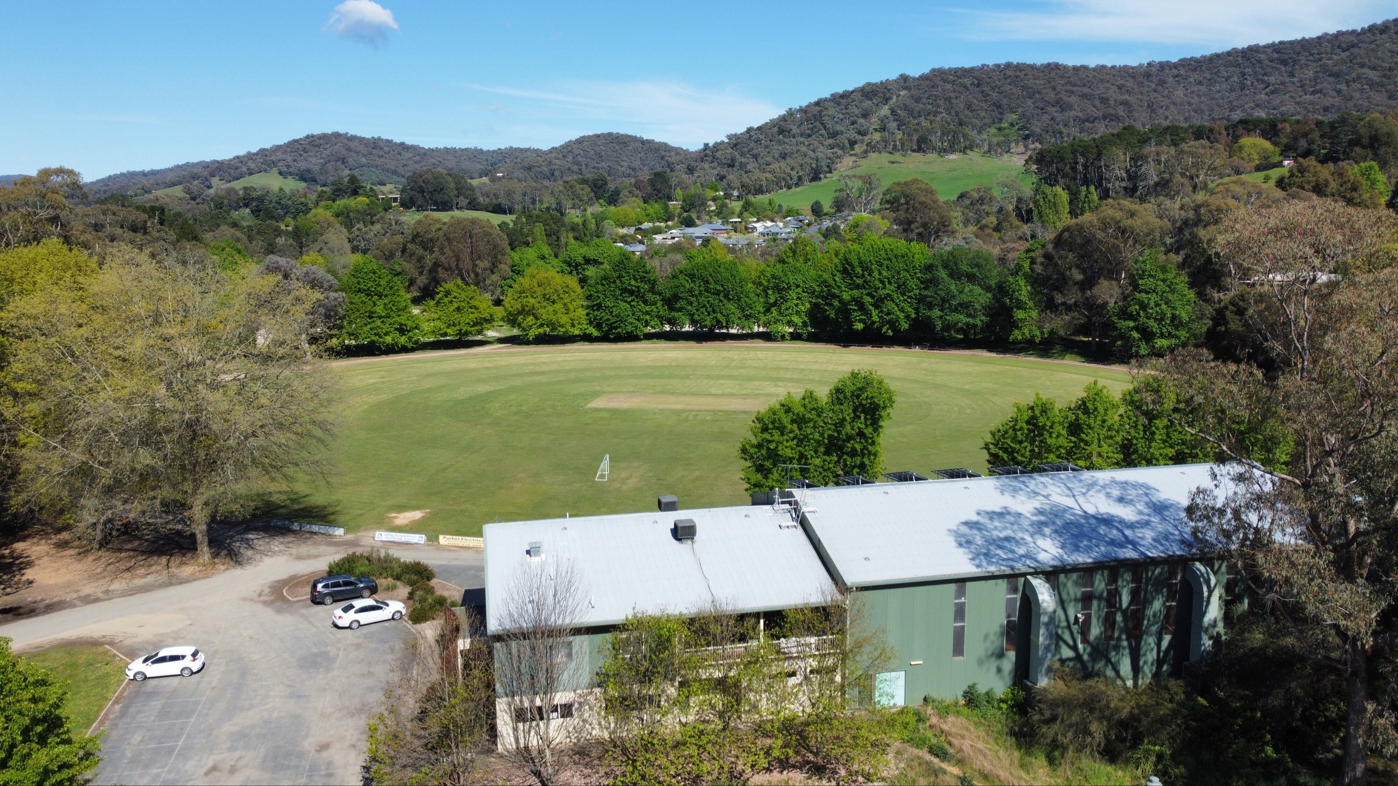 A community battery building in daylight next to a large field